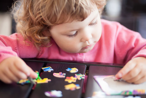 Child completing jigsaw puzzle