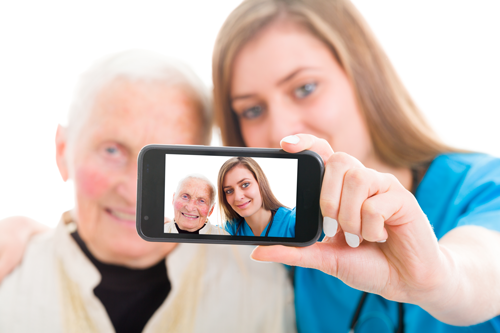 Elderly man and young woman taking a self portrait