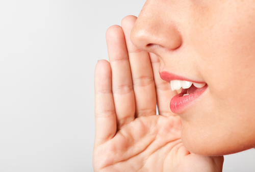 Woman whispering into someone's ear
