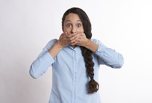 Woman with hand over her mouth